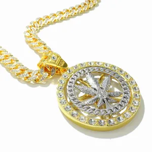 Detailed close-up of iced out rotating maple leaf pendant necklace with golden Cuban chain