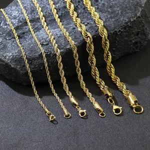 Detail von goldenen Edelstahl-Kordelketten in verschiedenen Stärken auf dunklem Fels.