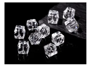 Macro detail of faceted transparent clear crystal cube beads for jewelry making.
