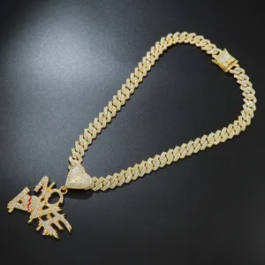 Detail of iced out No Love pendant with broken heart on a gold Cuban link chain
