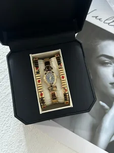 Gold oval watch set with red heart accents inside an elegant black gift box