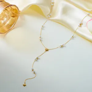 Detailed close-up of a delicate gold chain necklace with pearls and eight-pointed stars