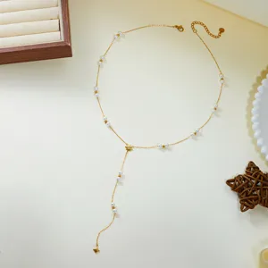 Close-up of elegant gold lariat necklace featuring small pearls and eight-pointed star pendant