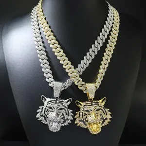 Gedetailleerd zicht op iced out tijgerkop hangers aan gouden en zilveren Cubaanse ketens
