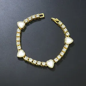 Detailansicht der goldenen Tenniskette mit weißen Emaille-Herzen und glänzenden Strasssteinen