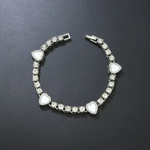 Detailaufnahme der weißen Herz-Anhänger an einer silbernen Strass-Tennis-Halskette