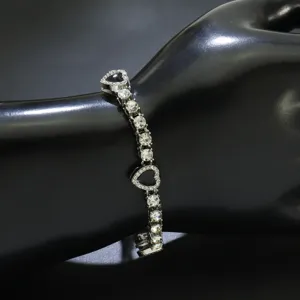 Nahaufnahme von Strass-Tennisarmband mit Herzanhänger auf Handmodell