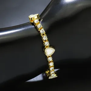 Detailaufnahme einer goldenen Herz-Tenniskette mit Strasssteinen und weißer Emaille-Einlage.