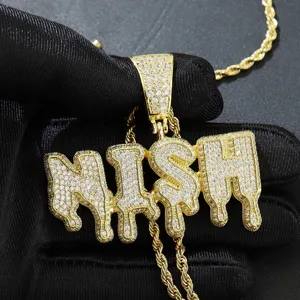 Nahaufnahme des vereisten NISH-Buchstabenanhängers mit goldener Kette