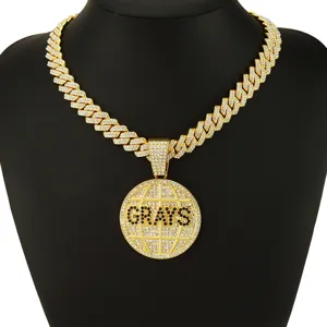 Detailansicht des mit Steinen besetzten runden GRAYS-Anhängers an einer goldfarbenen Kette