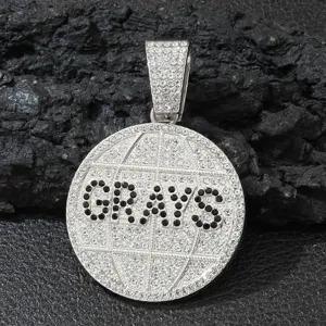 Nahaufnahme eines diamantbesetzten GRAYS Anhängers mit Erdmuster für Hip-Hop-Style