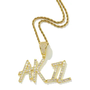 Nahaufnahme des AKIL Iced-Out-Buchstabenanhängers an einer 18k vergoldeten Kordelhalskette