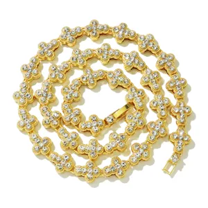 Makroansicht einer goldenen Tenniskette mit eisgekühlten Kreuzblumenmotiven und Kristallen.