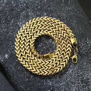 Close-up of gold-plated stainless steel Franco chain necklace on dark stone.