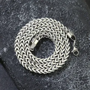 Close-up of stainless steel Franco chain showing intricate V-shaped weave and lobster clasp.
