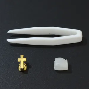 Gold single tooth grill set with cross design, includes tweezers and silicone wax