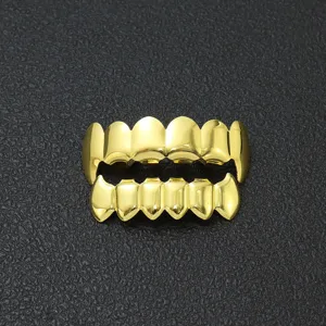 Primo piano dettagliato di grillz hip-hop placcati in oro con design a denti da vampiro