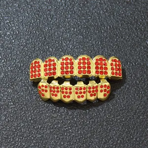 Macro detail view of hip hop gold plated teeth grills set with vibrant red rhinestones