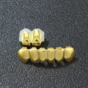 Detaillierte Nahaufnahme des glänzenden goldenen Hip-Hop-Zahn-Grillz-Sets auf schwarzem Grund