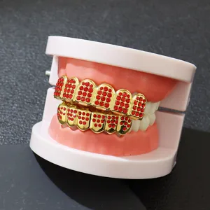 Detailed view of hip hop teeth grills with sparkling red rhinestones on gold base