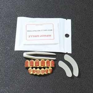 Detail view of hip-hop gold grillz set with red rhinestones and tools