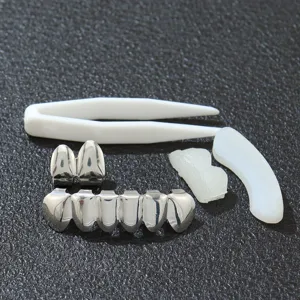 Detailansicht eines silbernen Hip-Hop-Grillz-Sets mit Pinzette und Formstäben auf Schwarz