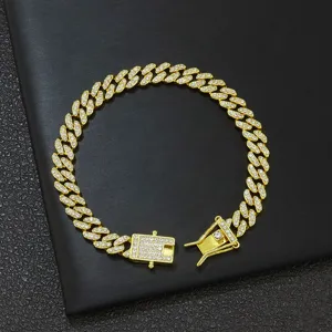Nahaufnahme der goldfarbenen Cuban-Kette mit Blatt-Gliedern und glitzernden Strasssteinen