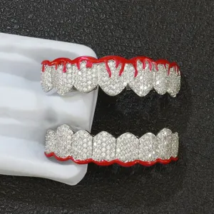 Detail view of red drip oil enamel and micro-pave CZ stones on silver-tone tooth grills