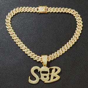 Nahaufnahme einer vereisten goldene Cubankette mit großem SB Masken-Anhänger Design