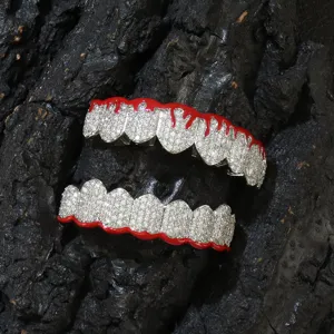 Macro view of silver color zircon paved copper dental grills with red oil drip detail
