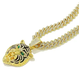 Nahaufnahme von Tigerkopf-Anhänger mit grünen Augen an goldener Panzerkette