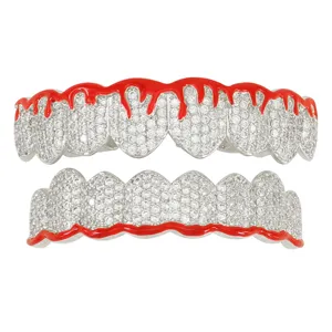 Detailed view of red dripping enamel grillz set with sparkling CZ stones on copper base.