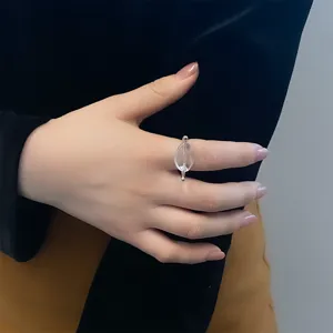 Detailopname van een elegante open ring met een heldere geometrische steen op de hand