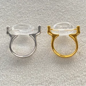 Gedetailleerde macro-opname van geometrische koperen ringen met ovale glazen stenen.