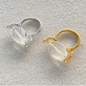 Detailopname van minimalistische geometrische ringen met helder glas in goud en zilver