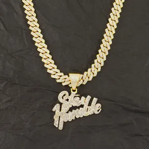 Close-up of iced out gold plated Stay Humble pendant on Cuban link chain necklace