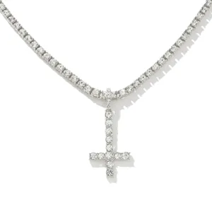 Close-up detail of silver inverted cross pendant necklace with sparkling rhinestones