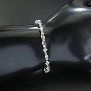 Detailansicht eines silbernen Tennisarmbands mit funkelnden Strass-Blumenkreuzen