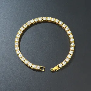 Close-up macro view of a gold plated alloy tennis bracelet with single row clear zirconia stones