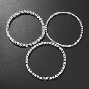 Macro view of three sparkling silver iced out tennis bracelets arranged on a dark background