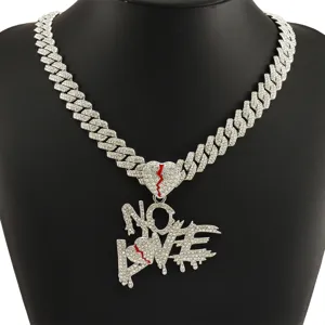 Detail view of iced out NO LOVE letter and broken heart pendant on a Cuban link chain.