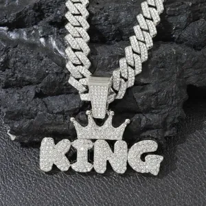 Close-up of sparkling iced out KING letter pendant with crown on a Cuban link chain