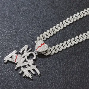 Macro view of iced out NO LOVE pendant with red heart crack on silver Cuban link chain