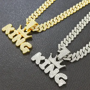 Detail of gold and silver iced out KING crown pendants with cuban chains