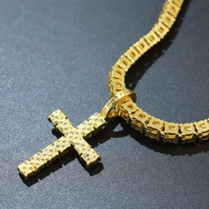 Nahaufnahme eines vereisten Kreuzanhängers an einer goldene Tenniskette mit Steinen