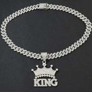 Detailed view of silver iced out king crown pendant with sparkling rhinestones