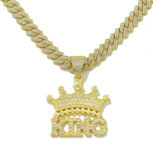 Close-up detail of a hip-hop iced out crown KING pendant necklace in gold finish
