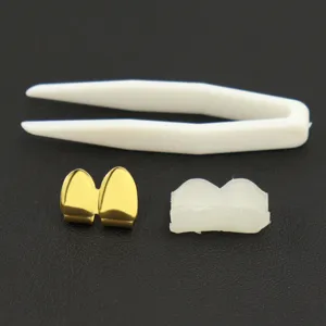 Detailed view of 18k gold plated hip-hop double fangs grillz kit with molding wax and tweezers