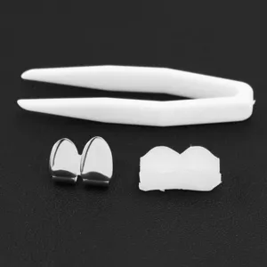 Macro view of hip hop silver plated grillz set including molding wax and tweezers