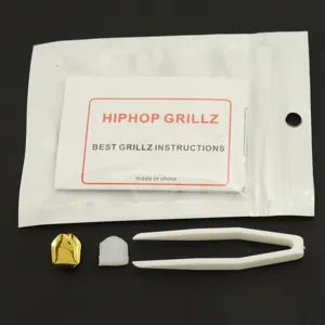 Detail view of single gold hip hop grillz set with tweezers and molding bar